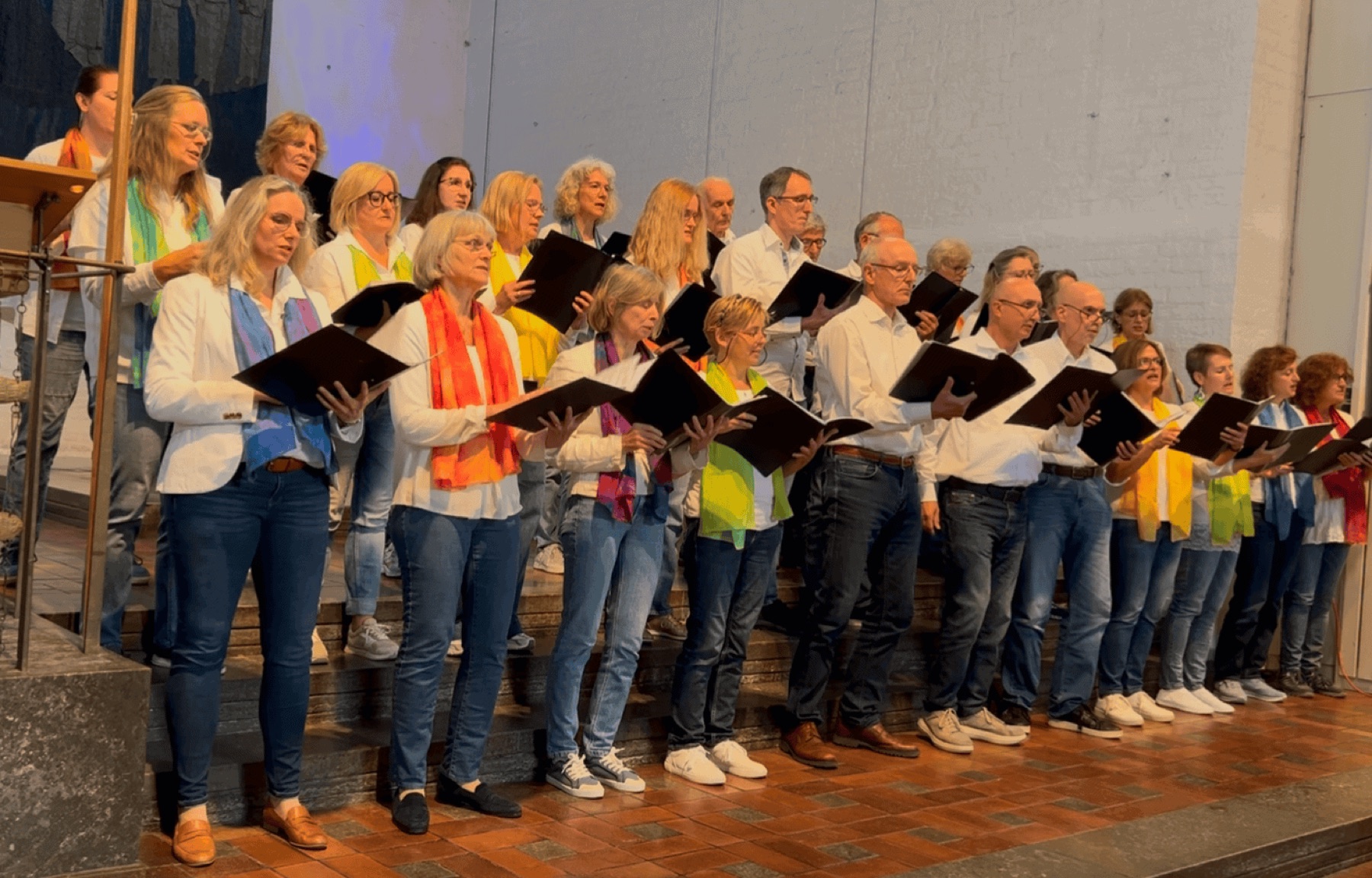Die Munich Souls singen im Konzert von ihren Notenmappen, im Hintergrund das Kirchenschiff