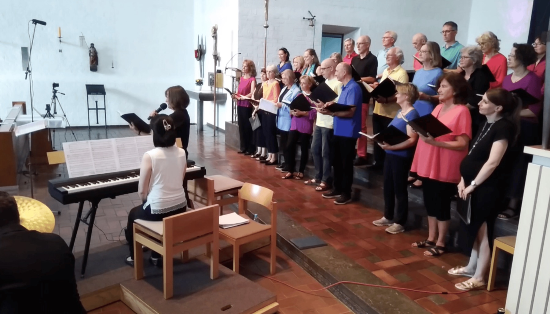 Seitlicher Blick über den singenden Chor beim Sommerkonzert 2024, links die Begleitung am Klavier